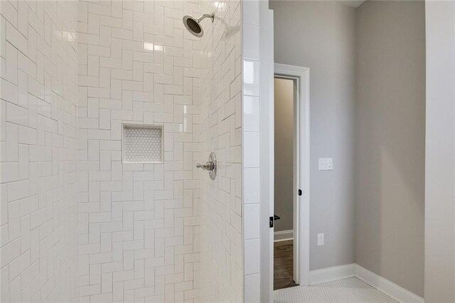 bathroom featuring tile patterned floors and a tile shower