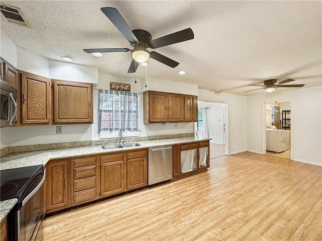 kitchen featuring sink, appliances with stainless steel finishes, a textured ceiling, light hardwood / wood-style floors, and ceiling fan