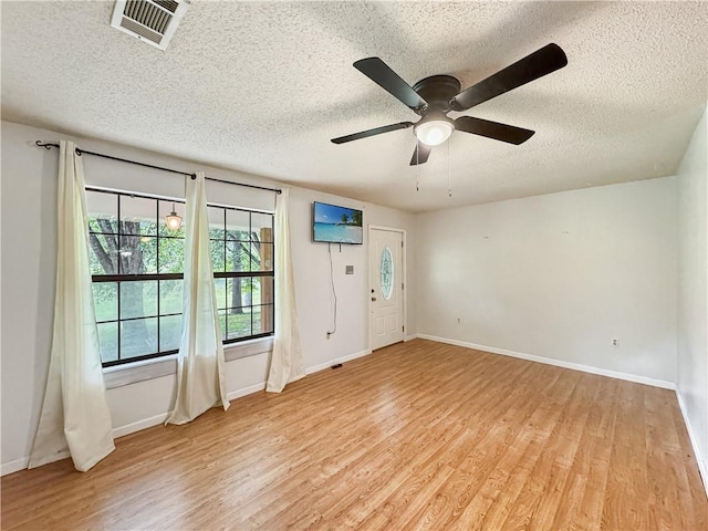 foyer entrance with a textured ceiling and light wood-type flooring