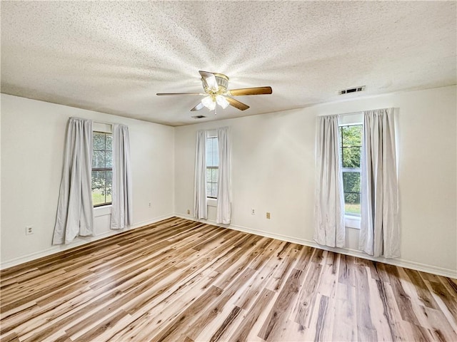 unfurnished room featuring light hardwood / wood-style flooring, a textured ceiling, and ceiling fan