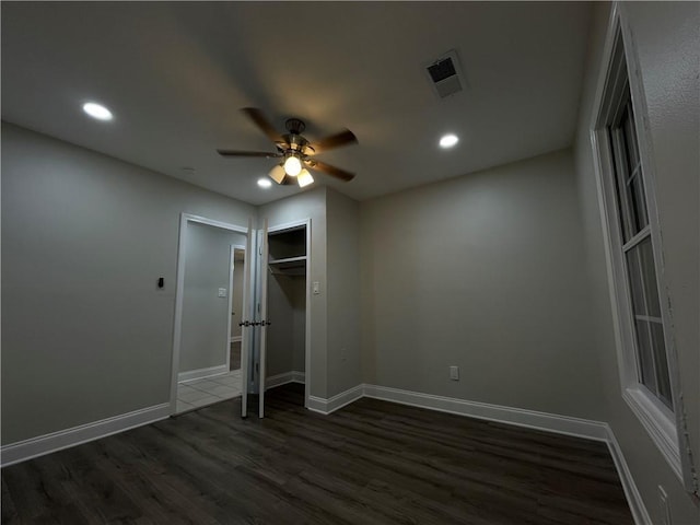 unfurnished bedroom with dark wood-type flooring, ceiling fan, and a closet