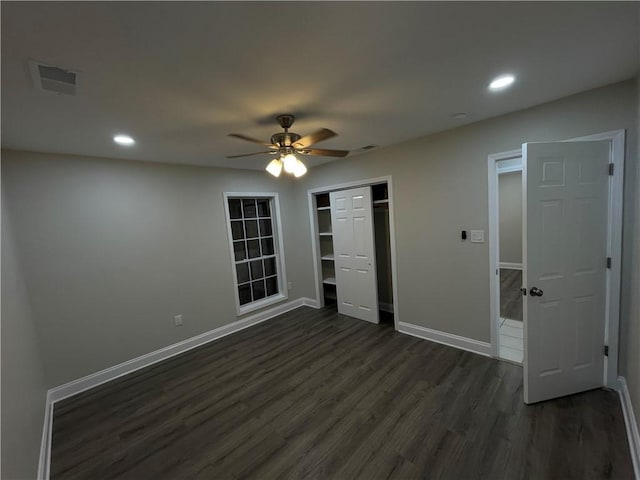 unfurnished bedroom featuring ceiling fan, dark hardwood / wood-style flooring, and a closet