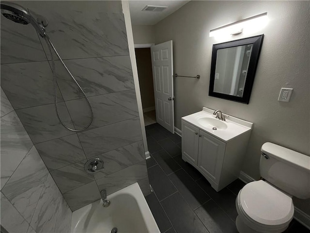 full bathroom with tiled shower / bath, vanity, and toilet