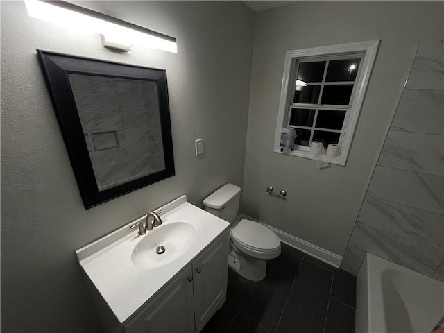 bathroom with vanity, a tub to relax in, and toilet