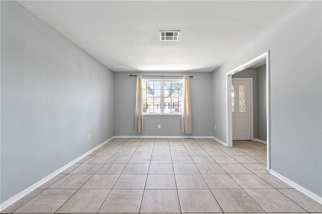 spare room with light tile patterned floors, visible vents, and baseboards