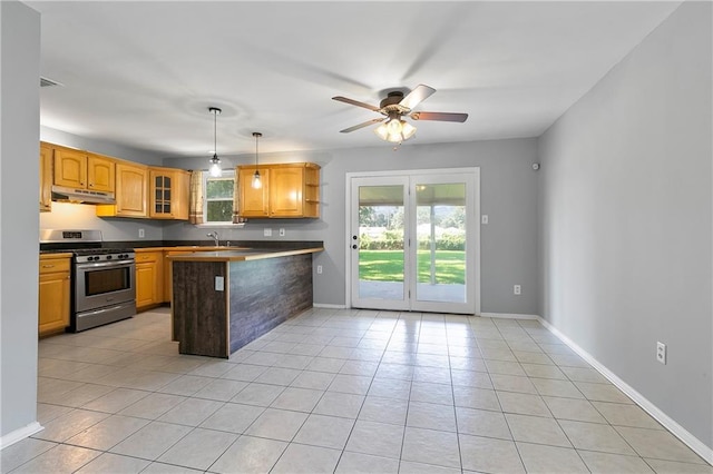 kitchen with under cabinet range hood, a peninsula, hanging light fixtures, stainless steel range with gas cooktop, and glass insert cabinets