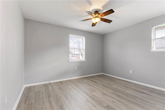 unfurnished room with a ceiling fan, plenty of natural light, light wood-style flooring, and baseboards