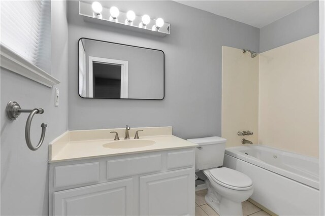 full bathroom with tile patterned flooring, vanity, washtub / shower combination, and toilet