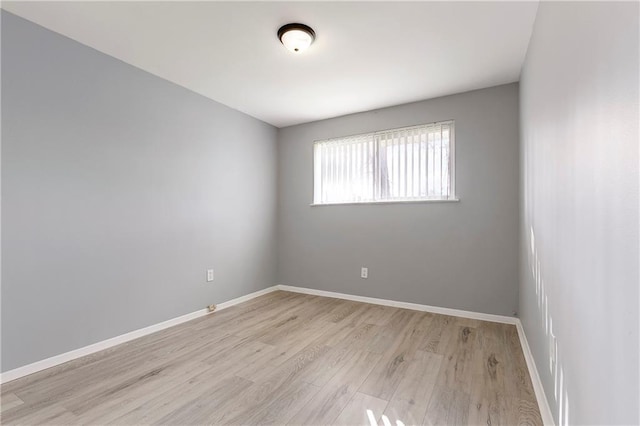 unfurnished room with light wood finished floors and baseboards