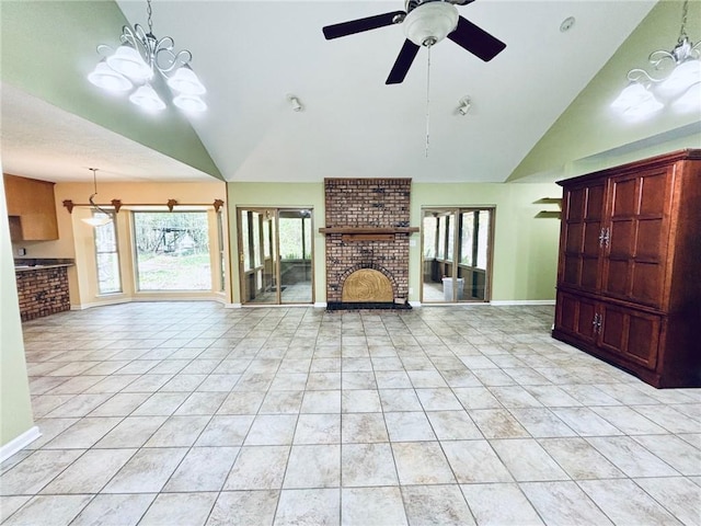 unfurnished living room with a fireplace, ceiling fan with notable chandelier, baseboards, and a healthy amount of sunlight