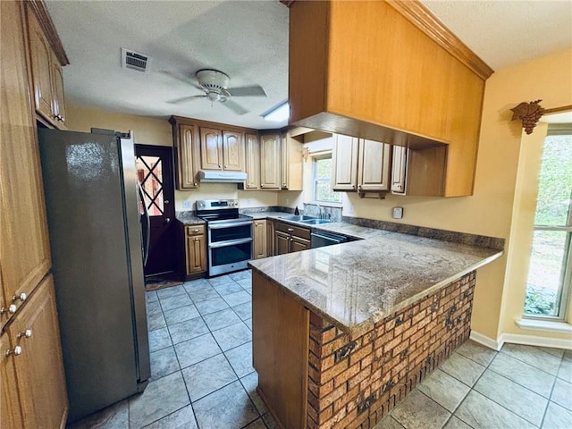 kitchen with appliances with stainless steel finishes, kitchen peninsula, a healthy amount of sunlight, and ceiling fan