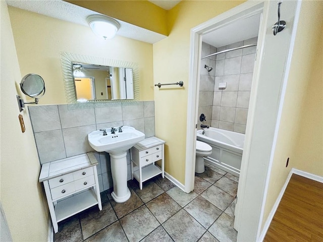 full bathroom featuring sink, toilet, tiled shower / bath, and tasteful backsplash