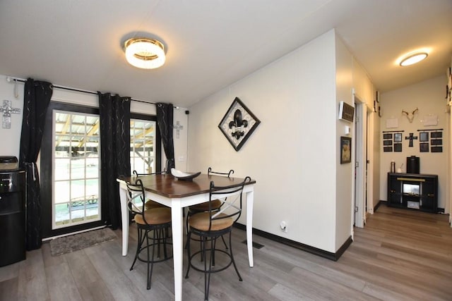 dining space featuring hardwood / wood-style floors and lofted ceiling