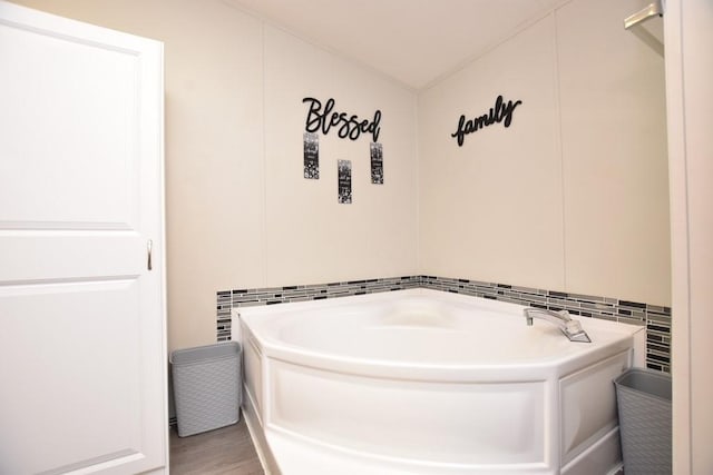 bathroom with a tub and tile walls