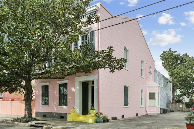 rear view of property with cooling unit and a balcony