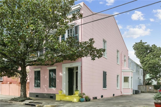 view of side of property featuring fence, crawl space, and central AC unit