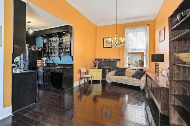 interior space featuring ornamental molding, a notable chandelier, bar, and dark wood-type flooring