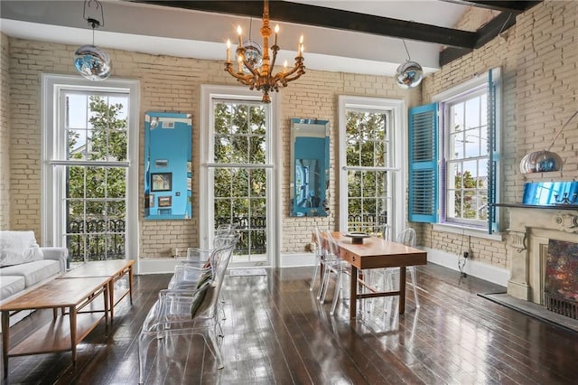 sunroom with beam ceiling and an inviting chandelier