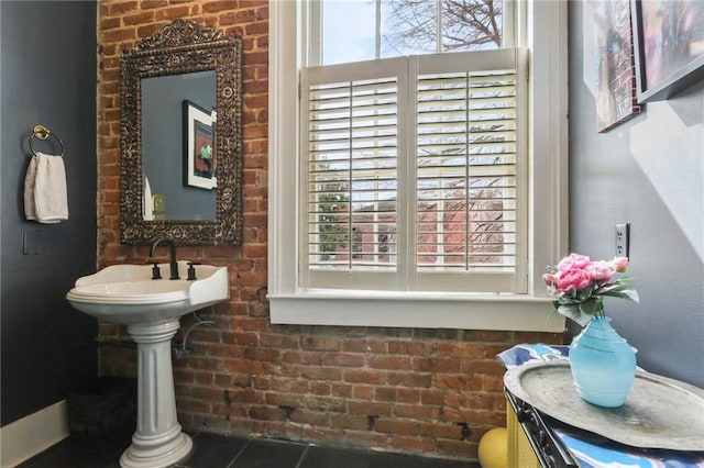 bathroom featuring brick wall