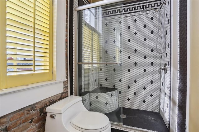 bathroom featuring an enclosed shower, toilet, and brick wall