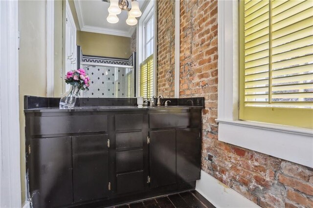 bathroom with ornamental molding, wood finished floors, a chandelier, and a sink