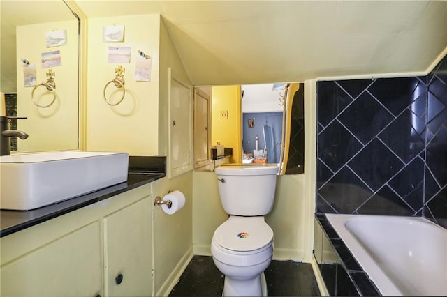 bathroom featuring baseboards, a tub, vanity, and toilet