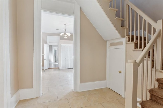 stairs featuring a notable chandelier and tile patterned floors