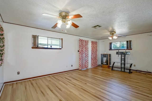 interior space featuring ceiling fan, a textured ceiling, and light hardwood / wood-style flooring