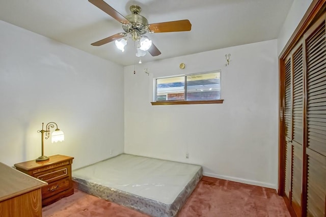 carpeted bedroom featuring ceiling fan and a closet