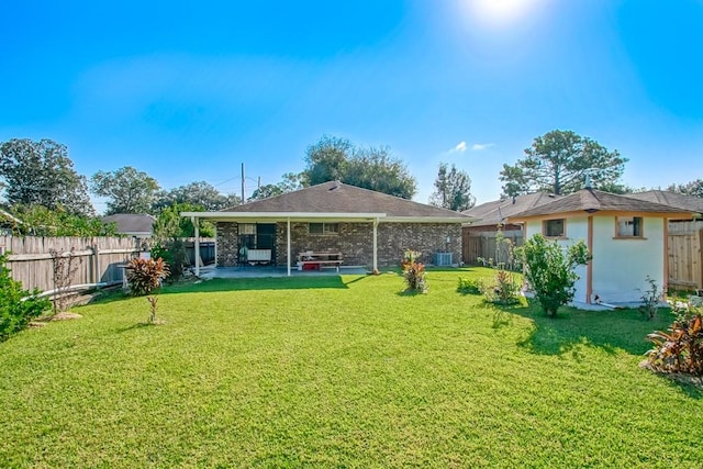 rear view of property featuring a lawn and a patio area