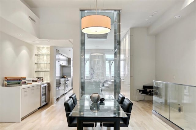 dining space featuring light hardwood / wood-style flooring and wine cooler