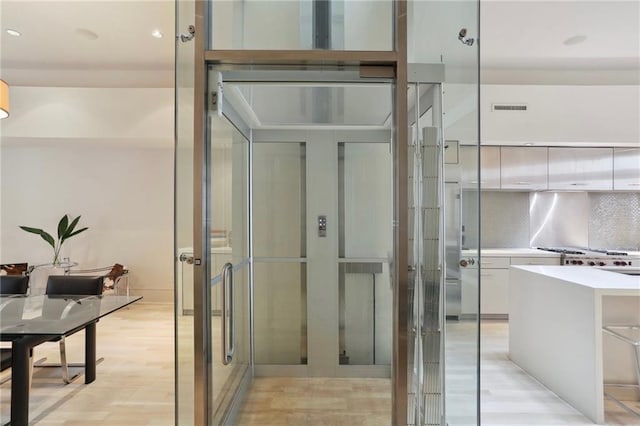 bathroom featuring wood-type flooring and decorative backsplash