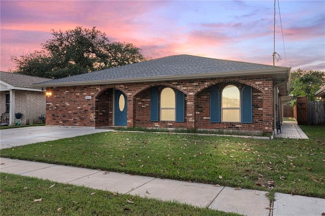 ranch-style home with a lawn