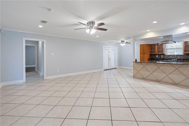 unfurnished living room with ornamental molding, ceiling fan, and light tile patterned floors