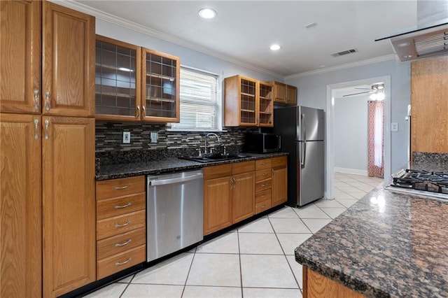 kitchen with tasteful backsplash, sink, stainless steel appliances, ornamental molding, and light tile patterned floors