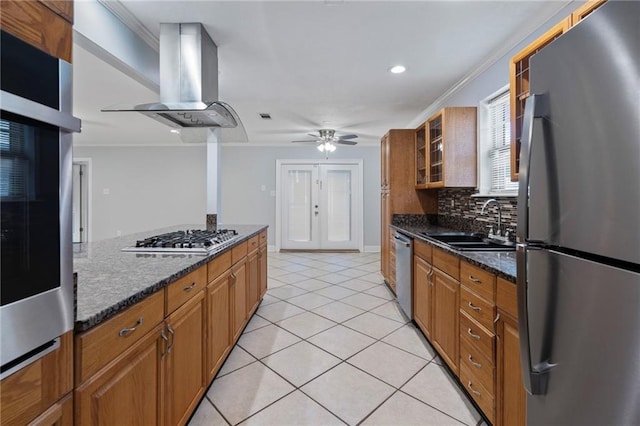 kitchen with sink, backsplash, wall chimney range hood, stainless steel appliances, and dark stone countertops