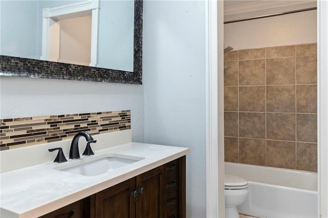 full bathroom featuring toilet, vanity, tiled shower / bath, and backsplash