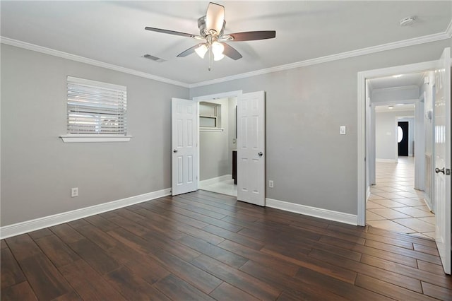 unfurnished bedroom with a spacious closet, ceiling fan, a closet, dark hardwood / wood-style flooring, and ornamental molding