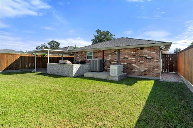 rear view of house featuring a patio, a lawn, and central AC unit