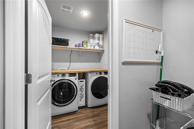 laundry area with wood-type flooring and washing machine and dryer