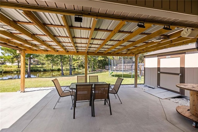 view of patio featuring a water view and a trampoline