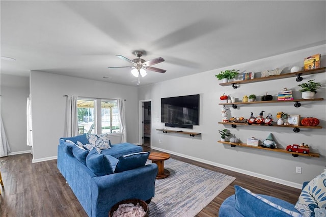 living room featuring ceiling fan and dark wood-type flooring