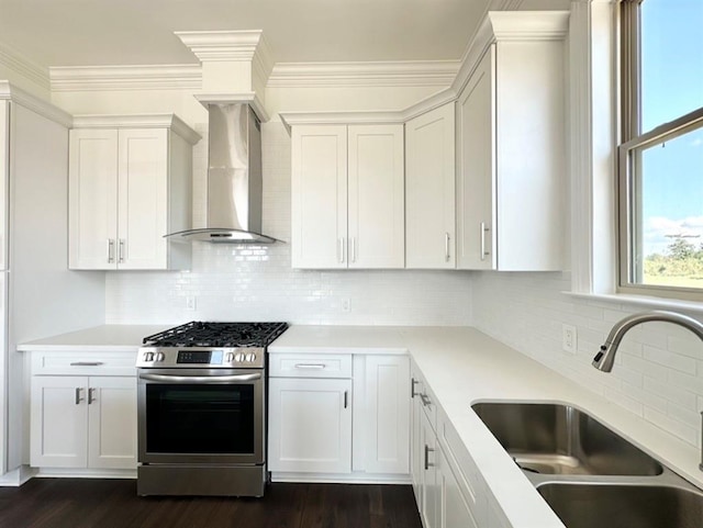 kitchen featuring white cabinets, sink, stainless steel gas stove, wall chimney exhaust hood, and dark hardwood / wood-style floors