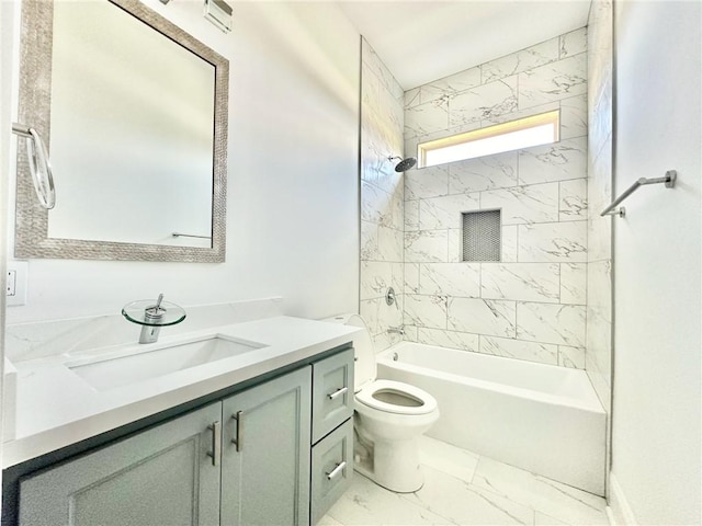 full bathroom featuring tiled shower / bath, vanity, and toilet