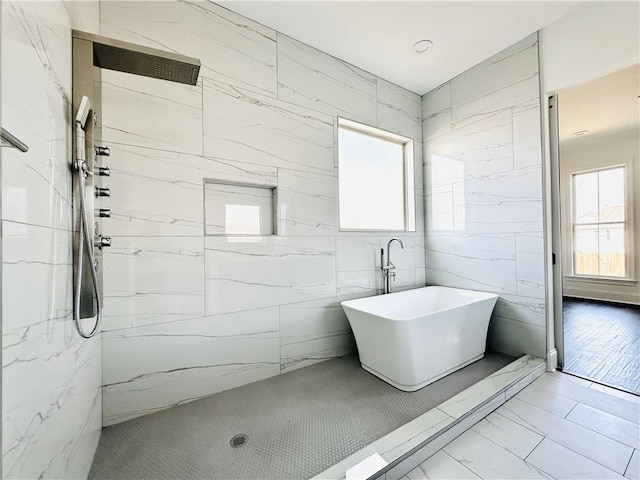 bathroom featuring shower with separate bathtub and a healthy amount of sunlight