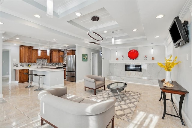 tiled living room featuring a tray ceiling, crown molding, and sink