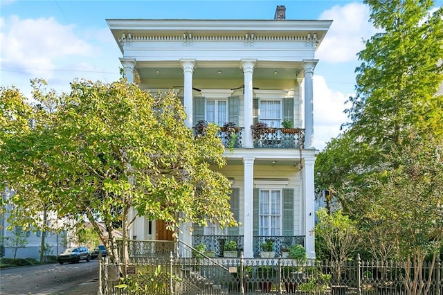 greek revival inspired property featuring a porch