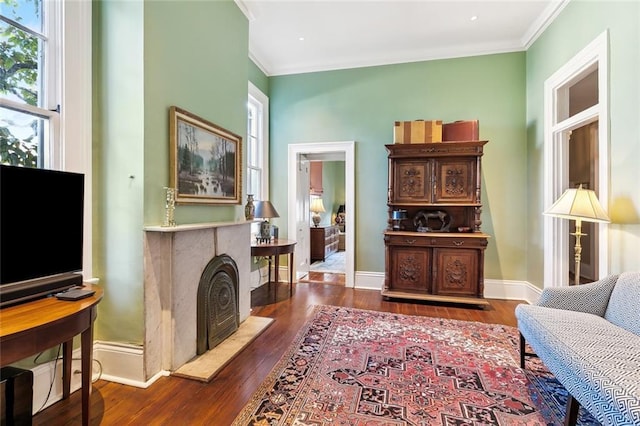 living area with ornamental molding and dark wood-type flooring