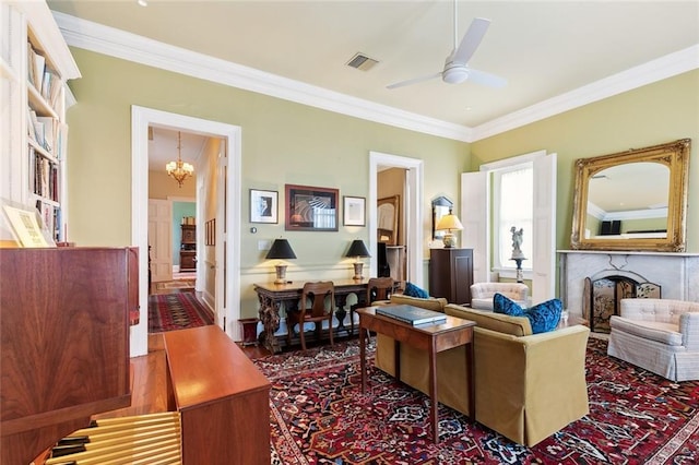 sitting room featuring ceiling fan with notable chandelier and ornamental molding