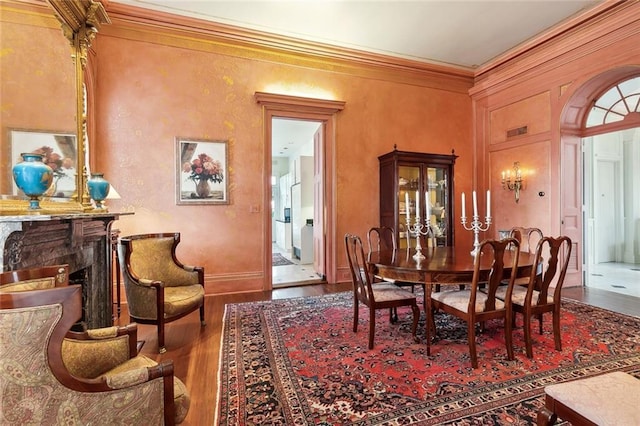 dining space with wood-type flooring and ornamental molding